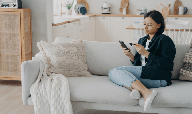 Woman at home entering credit card information into phone