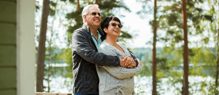 Happy older couple embracing on their porch