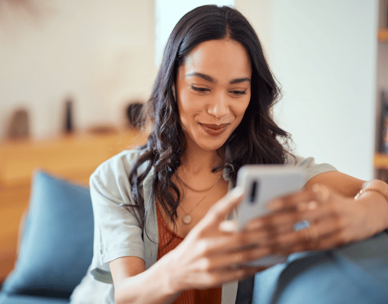 Young woman smiling at smartphone