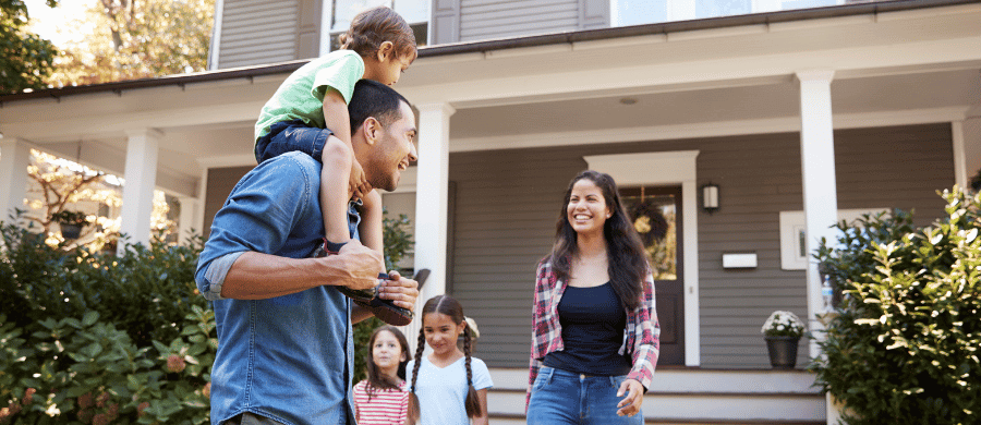 Young family of four outside their new home